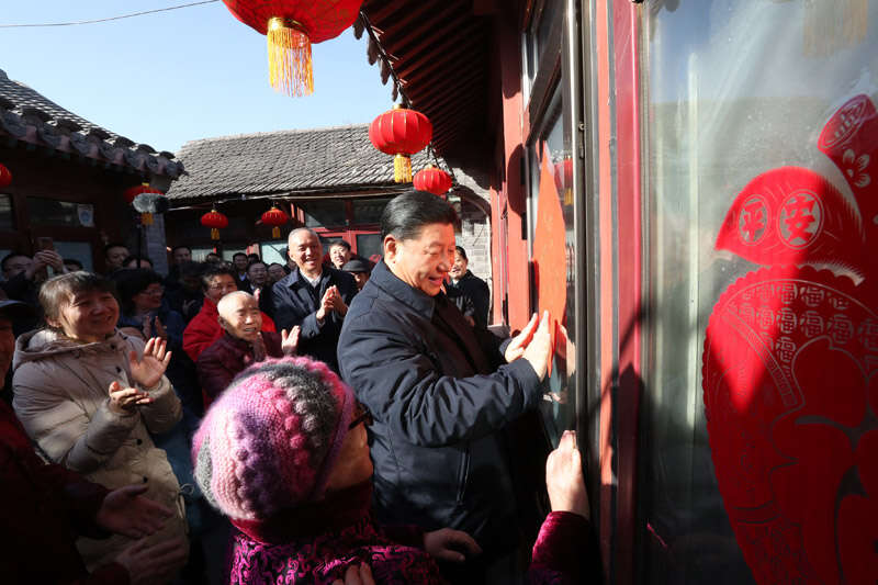 2019年2月1日上午，習(xí)近平在北京前門(mén)東區(qū)草廠四條胡同32號(hào)院，高興地拿起一幅“?！弊?，親自貼到門(mén)上，給這里的老街坊們拜年。新華社記者 鞠鵬 攝