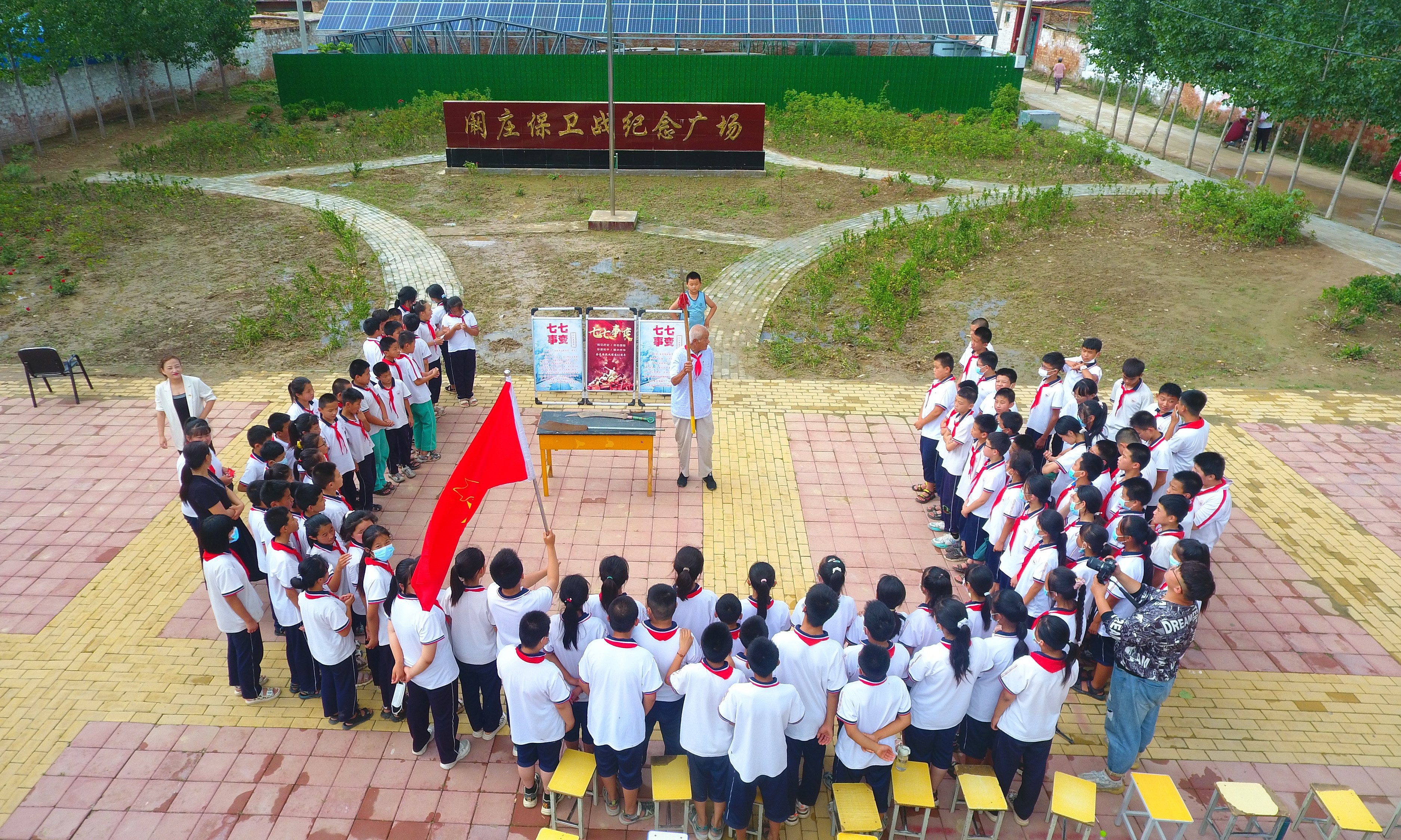 2022年7月6日，山東省聊城市，在茌平區(qū)菜屯鎮(zhèn)闞莊村的闞莊保衛(wèi)戰(zhàn)紀(jì)念廣場，闞莊保衛(wèi)戰(zhàn)親歷者王光木老人，為小學(xué)生們講述抗戰(zhàn)故事，展示大刀、長矛。